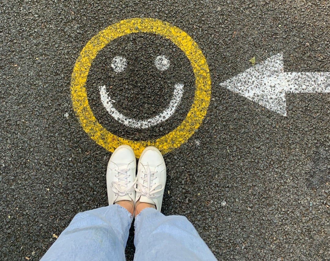 person in white shoes standing on gray concrete road