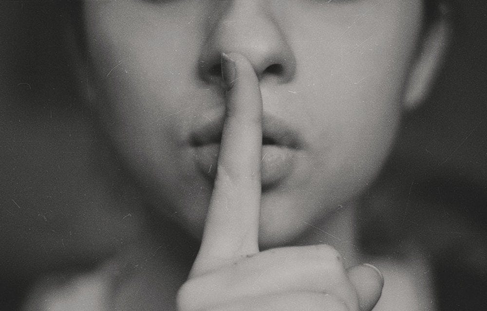 grayscale photo of woman doing silent hand sign grayscale photo of woman doing silent hand sign