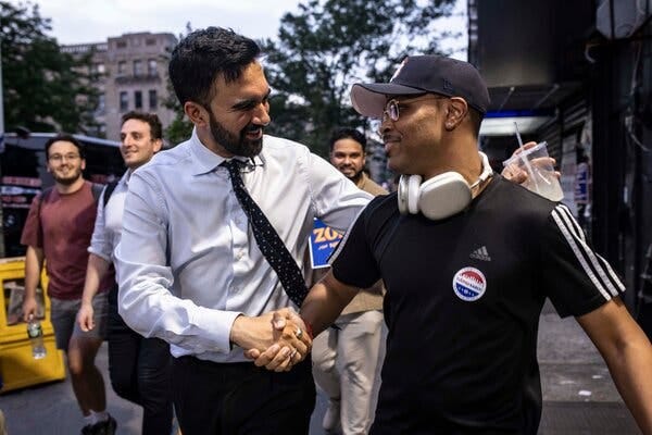 Mr. Mamdani shakes the hand of a supporter, his over-the-ears headphones around his neck, as he walked the length of Manhattan.