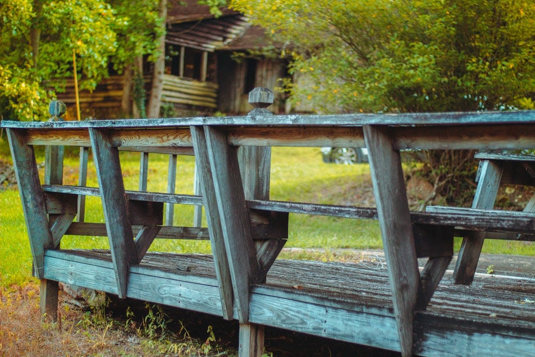 a wooden bench sitting on top of a lush green field a wooden bench sitting on top of a lush green field