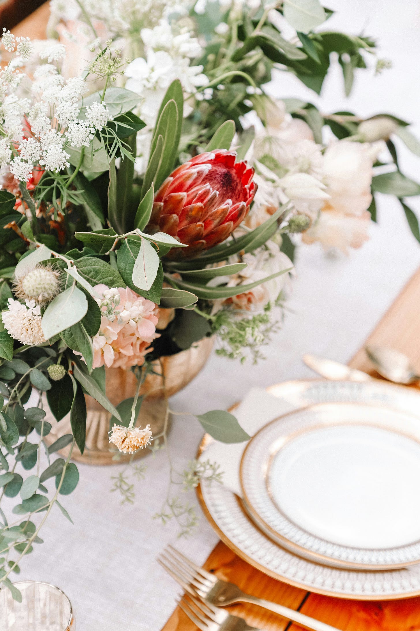 flower arrangement on a table next to a place setting