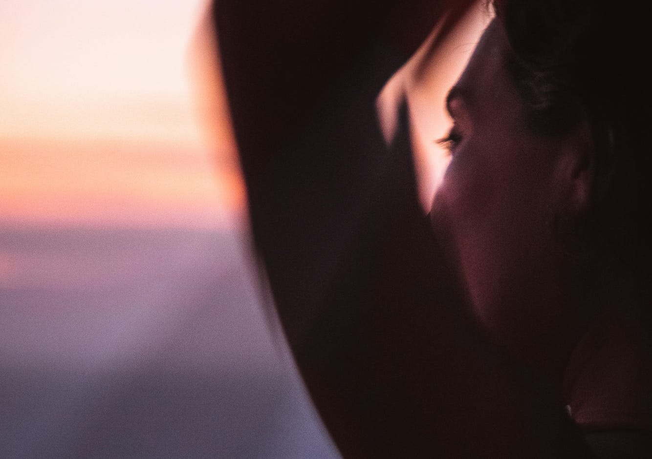 contemplative woman looking out over horizon at sunset contemplative woman looking out over horizon at sunset