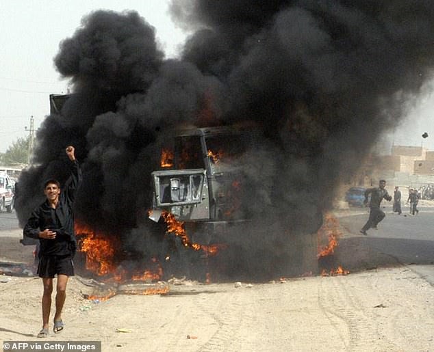 An Iraqi youth celebrates before a burning US army vehicle following an ambush on a US army convoy in the town of Khaldiyah, 80 kms west of Baghdad, 18 September 2003 An Iraqi youth celebrates before a burning US army vehicle following an ambush on a US army convoy in the town of Khaldiyah, 80 kms west of Baghdad, 18 September 2003