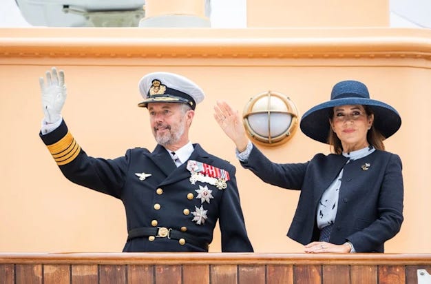 Queen Mary and King Frederik waving from a tangerine orange cruise ship