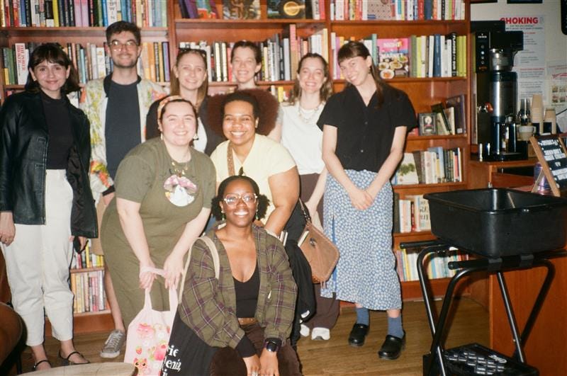 A group of adult friends in front of a large bookshelf in Liz's Book Bar