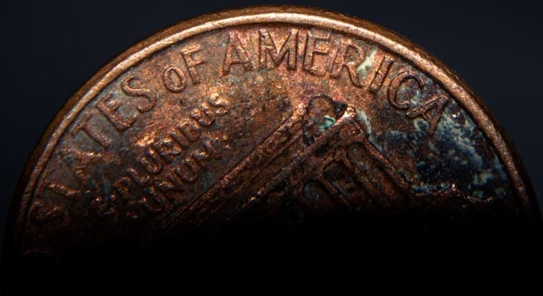 a close up of a penny on a black background