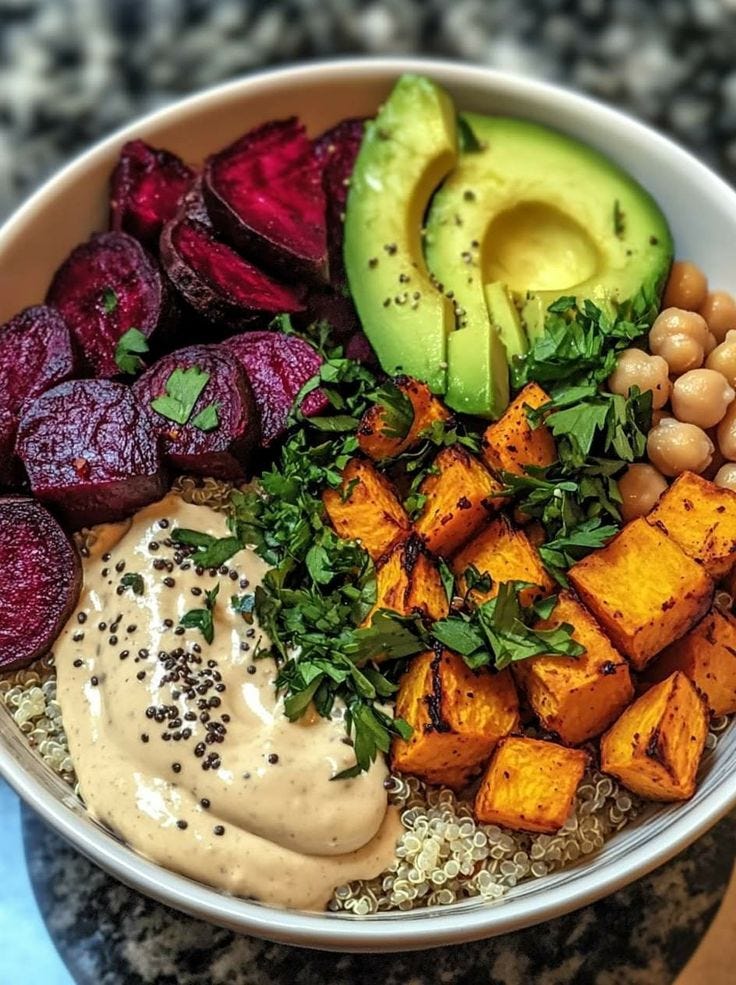 This may contain: a bowl filled with different types of food on top of a marble counter next to an avocado This may contain: a bowl filled with different types of food on top of a marble counter next to an avocado