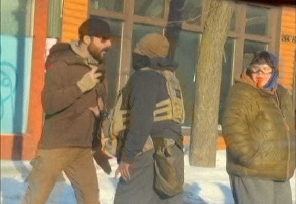 Screengrab from video footage showing Alex Pretti (L) and a federal immigration agent (C) before Pretti was shot dead.