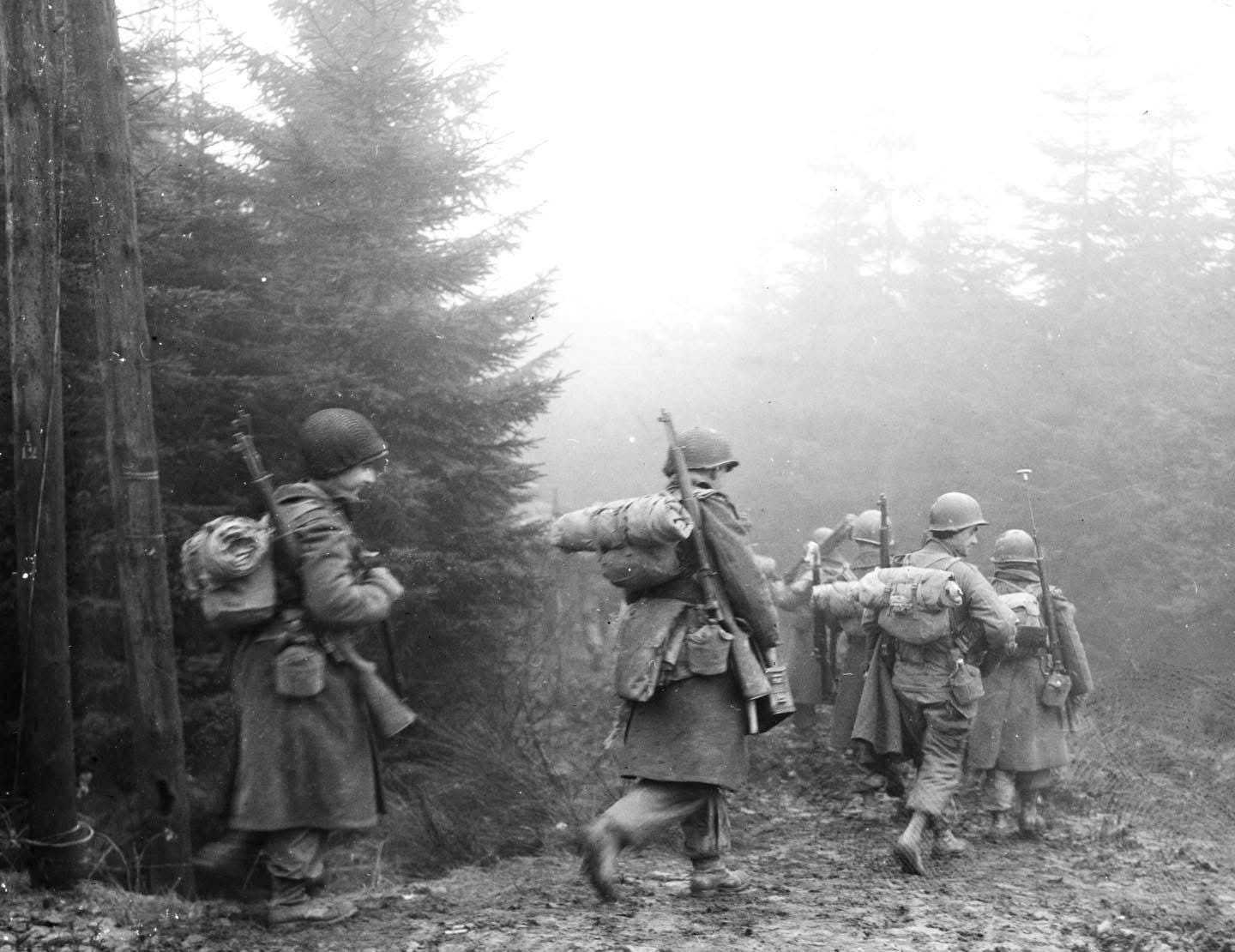 Soldiers of the 2nd Battalion, 325th Glider Regiment, US 82nd Airborne Division, advance through heavy fog near Werbomont, Belgium, during the fierce Battle of the Bulge, December 20, 1944.