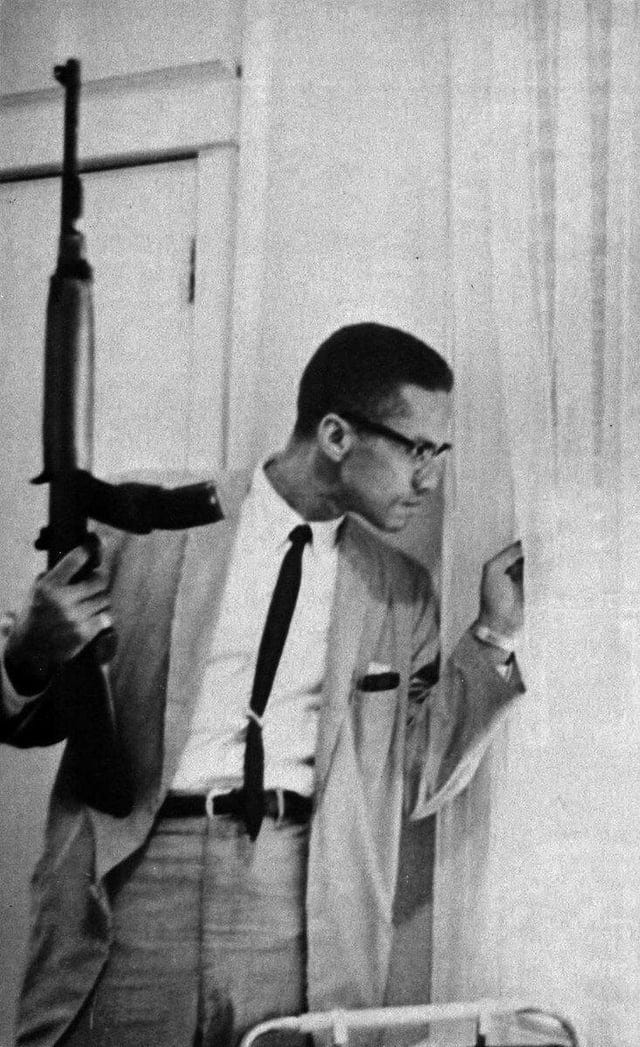 Malcolm X with a rifle, peering out the window of his home in 1964 : r/pics