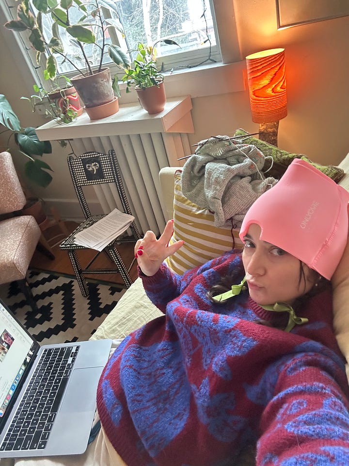 phoebe laying down on her couch. She has brown hair and big glasses