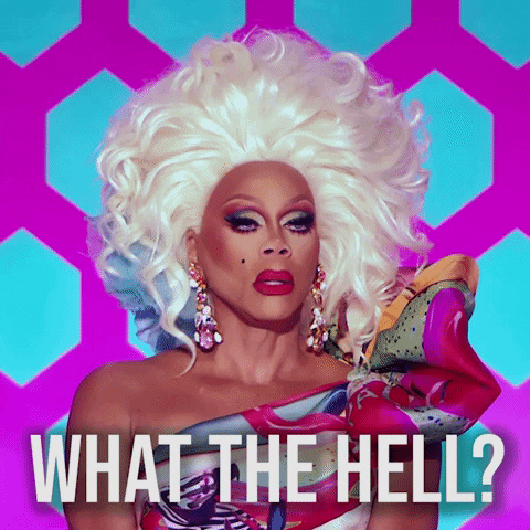 Reality TV gif. RuPaul in RuPaul's Drag Race wears a voluminous blonde wig and colorful one-shoulder top with a puffy sleeve. Text, "What the hell?" Reality TV gif. RuPaul in RuPaul's Drag Race wears a voluminous blonde wig and colorful one-shoulder top with a puffy sleeve. Text, "What the hell?"