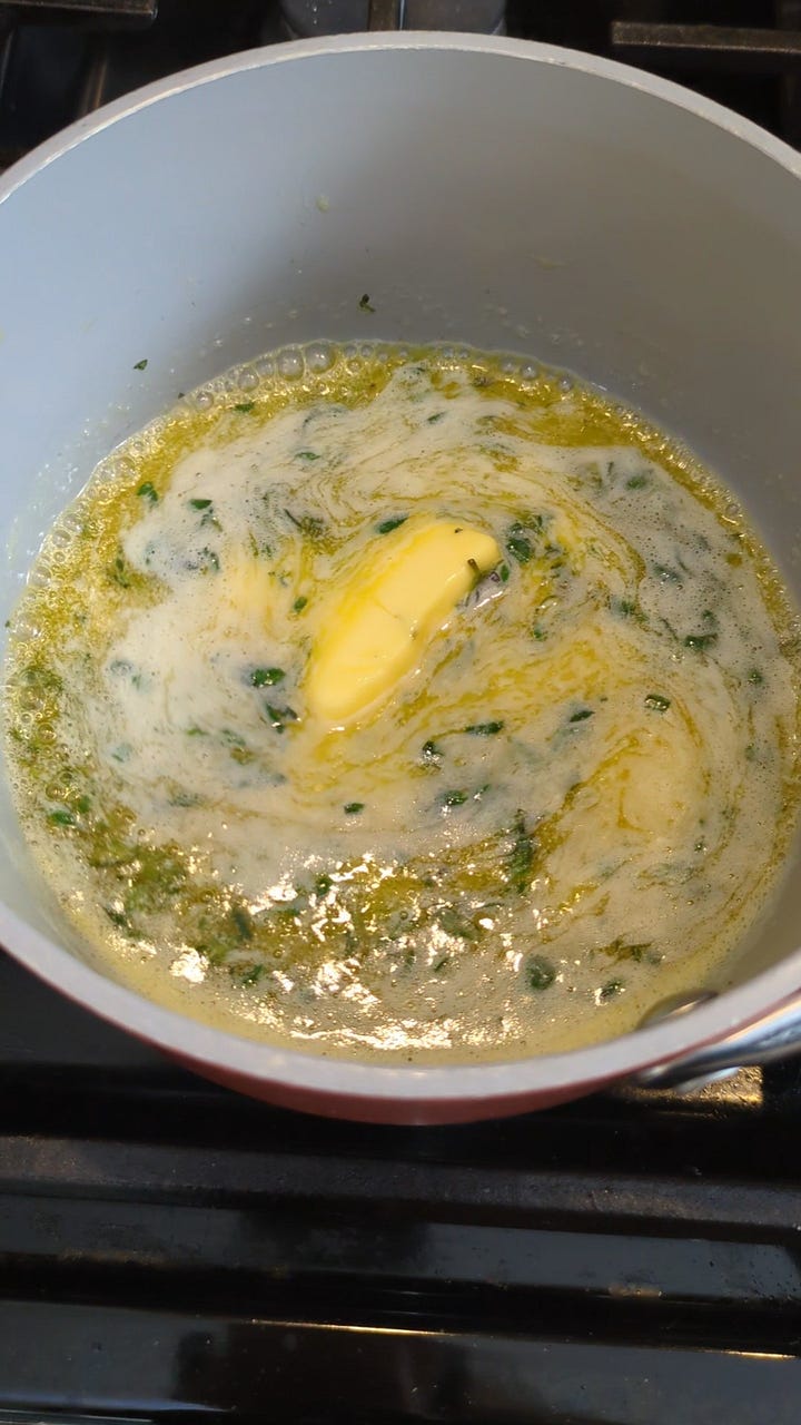 Butter melting with thyme and salt. Cutting loaf.