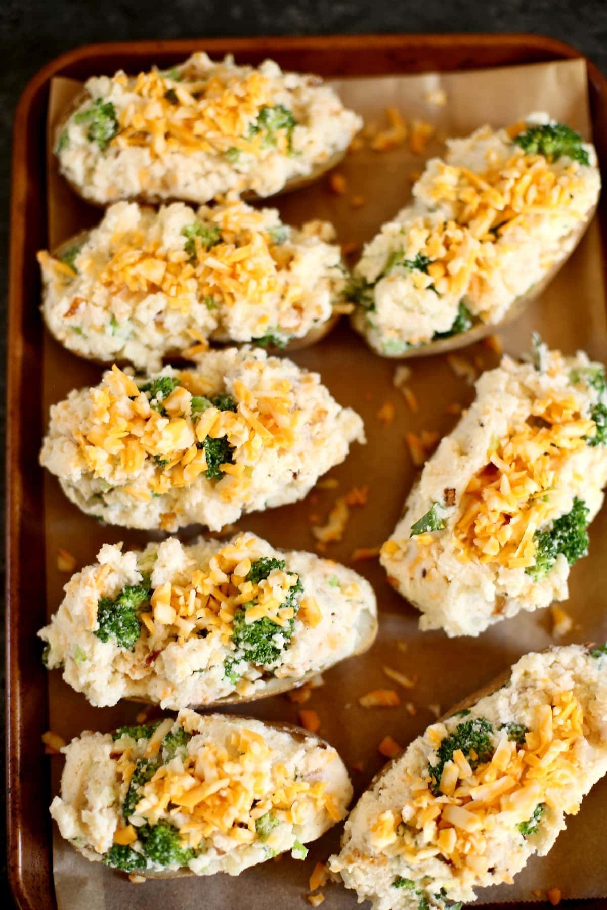 uncooked twice stuffed potatotes on a baking sheet.