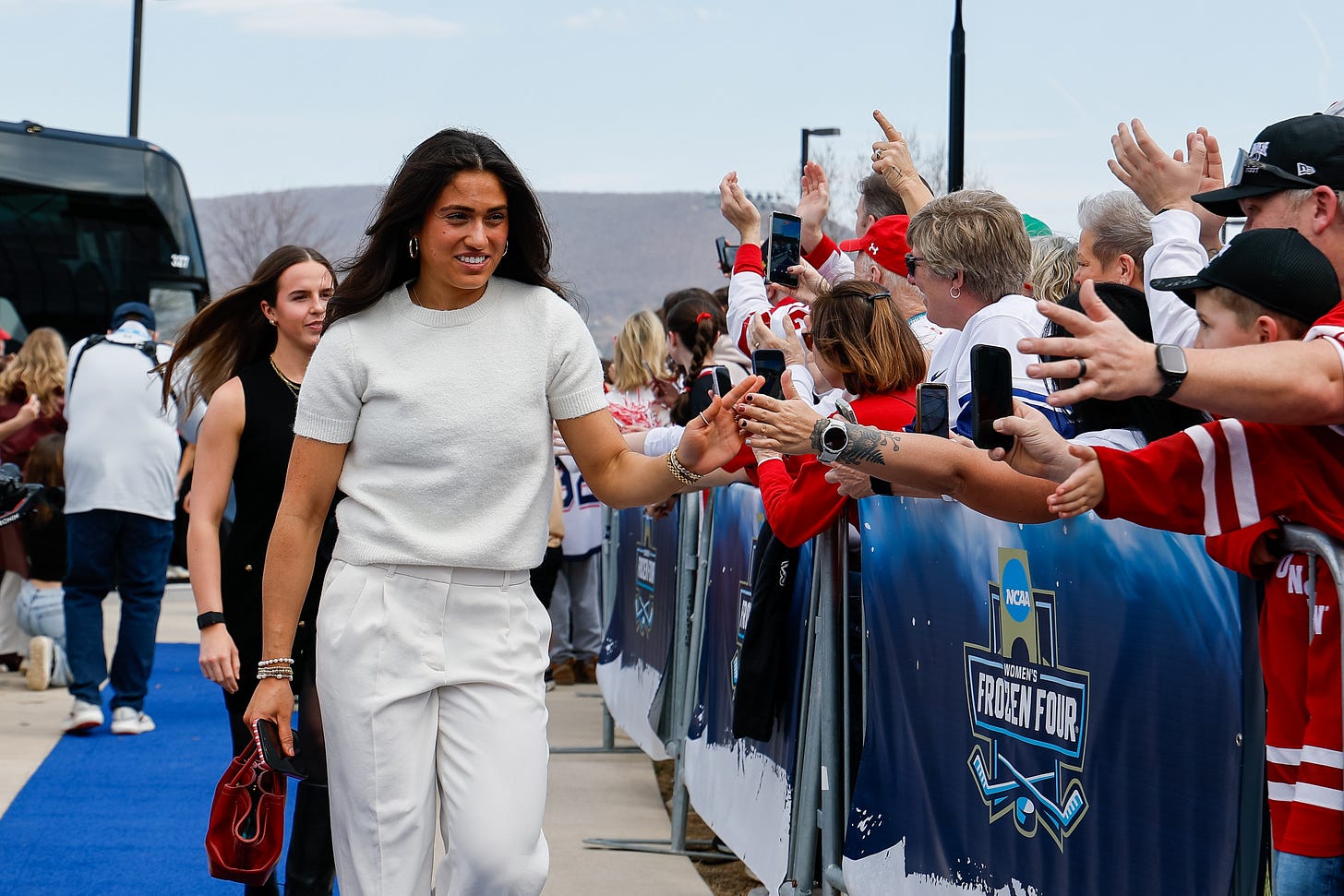 Emma venusio in a cream colored outfit high fiving fans 