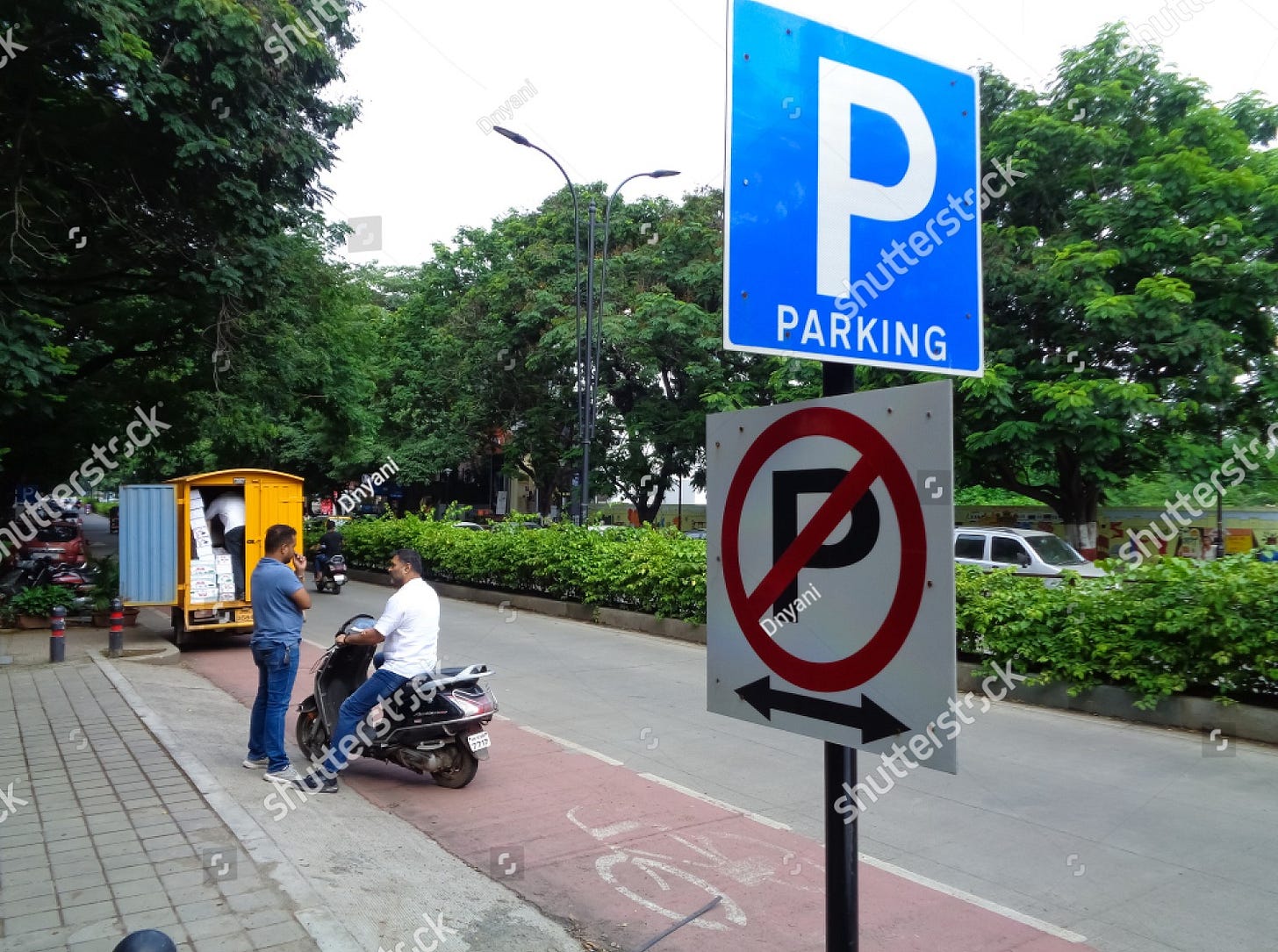 Pune, MH/INDIA- DEC 22, 2019: 'parking' and 'no parking' signs installed on single pole at DP Road Pune, simingly confusing people either park here or not.