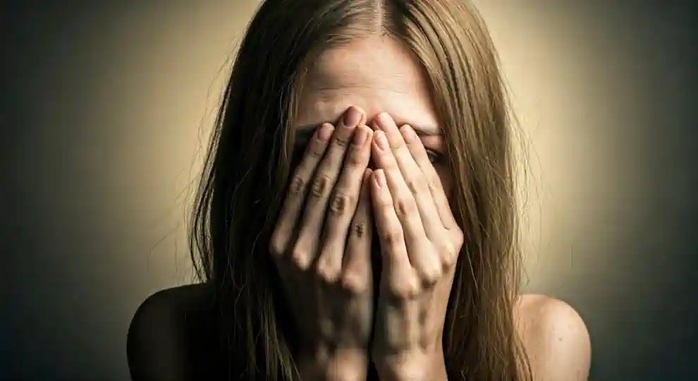 Empowering Women: Overcoming Autoimmune Disease Struggles A young woman, pale, sick and visibly troubled, with her hands covering her face.