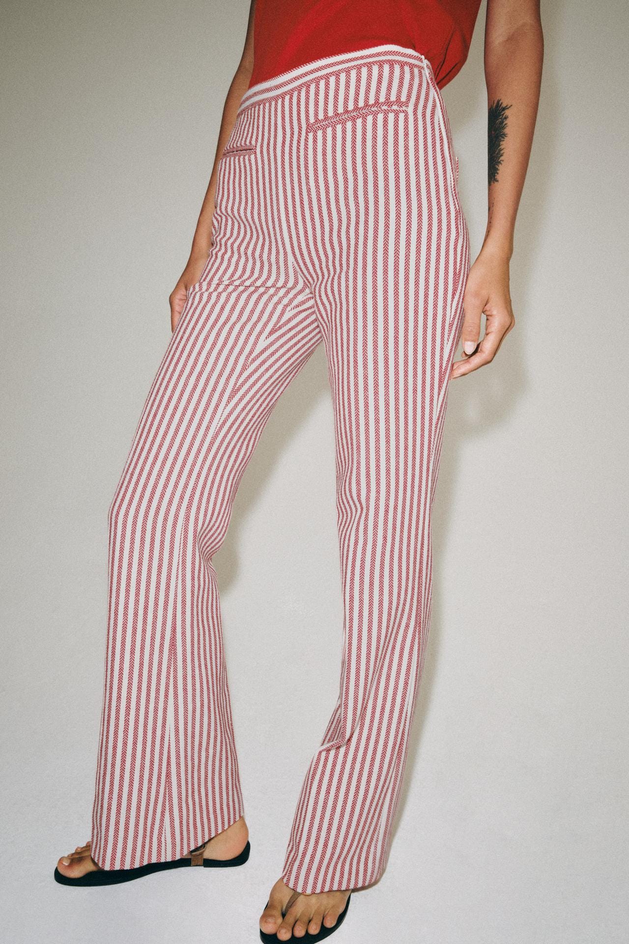 Red top and red and white striped long pants set. Mid-rise design, straight cut, and front welt pockets. Red top and red and white striped long pants set. Mid-rise design, straight cut, and front welt pockets.