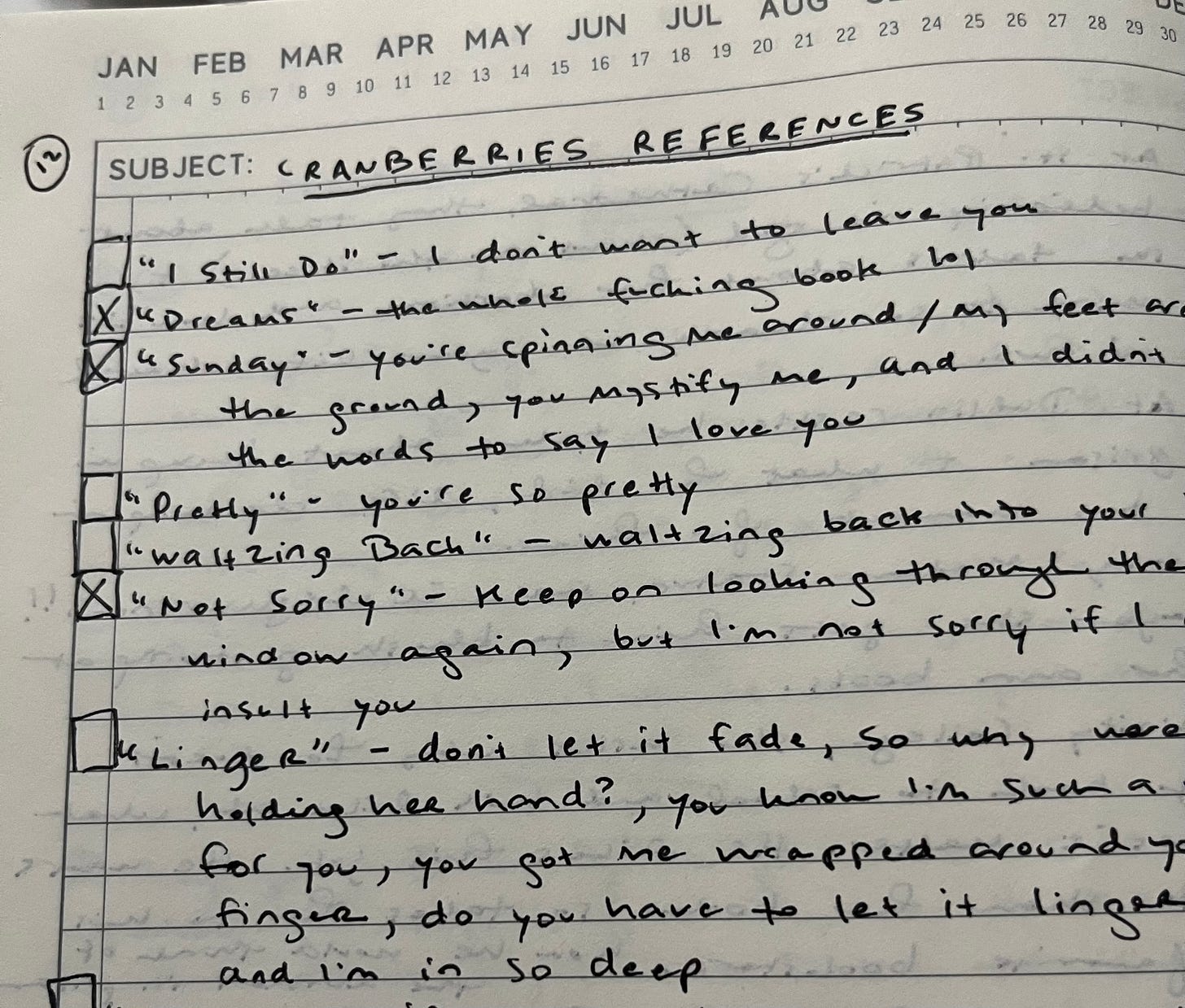 Page from notebook that says "Cranberries references" and then has songs listed with x's next to some of them to indicate that I've worked a reference into my book