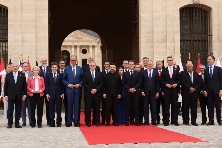 French President Emmanuel Macron and Ukrainian President Volodymyr Zelensky pose for a group photo with heads of states and governments ahead of the Coalition of the Willing summit on security guarantees for Ukraine at the Hotel des Invalides in Paris, France, Monday, July 13, 2026. (Teresa Suarez/POOL photo via AP)