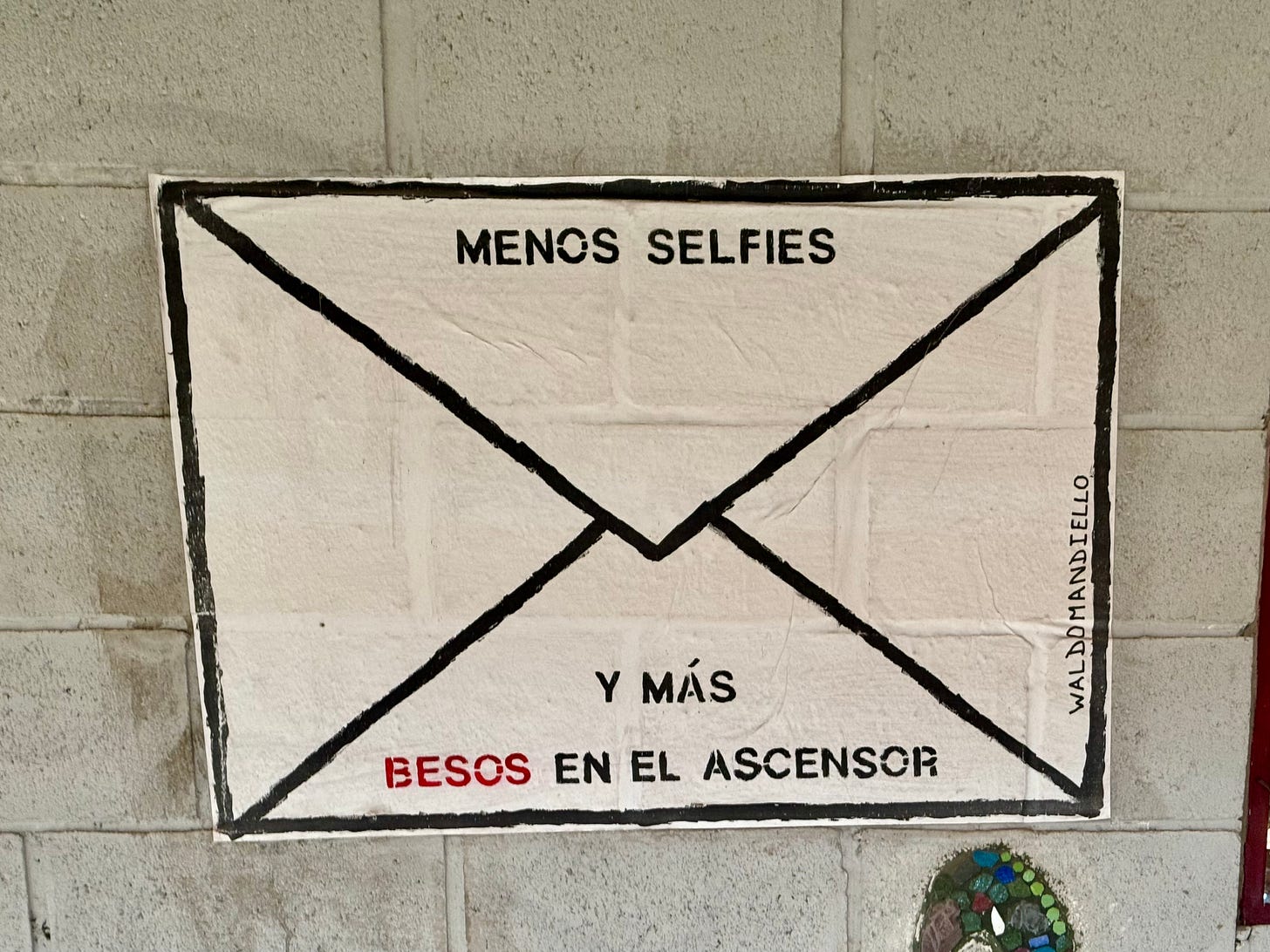Grafiti en Buenos Aires. Un sobre con el mensaje de Menos selfies y más besos en el ascensor. Foto propia.