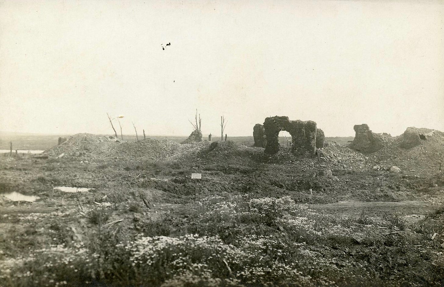 Flanders town In ruins with water-filled craters on the left.