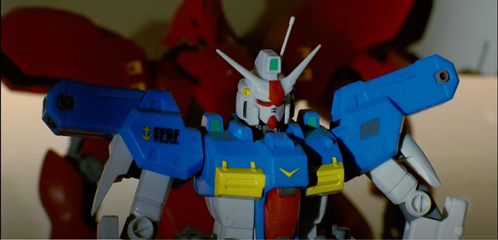 A collection of screenshots from the Somewhere I Belong music video featuring several small plastic models from different Gundam series.