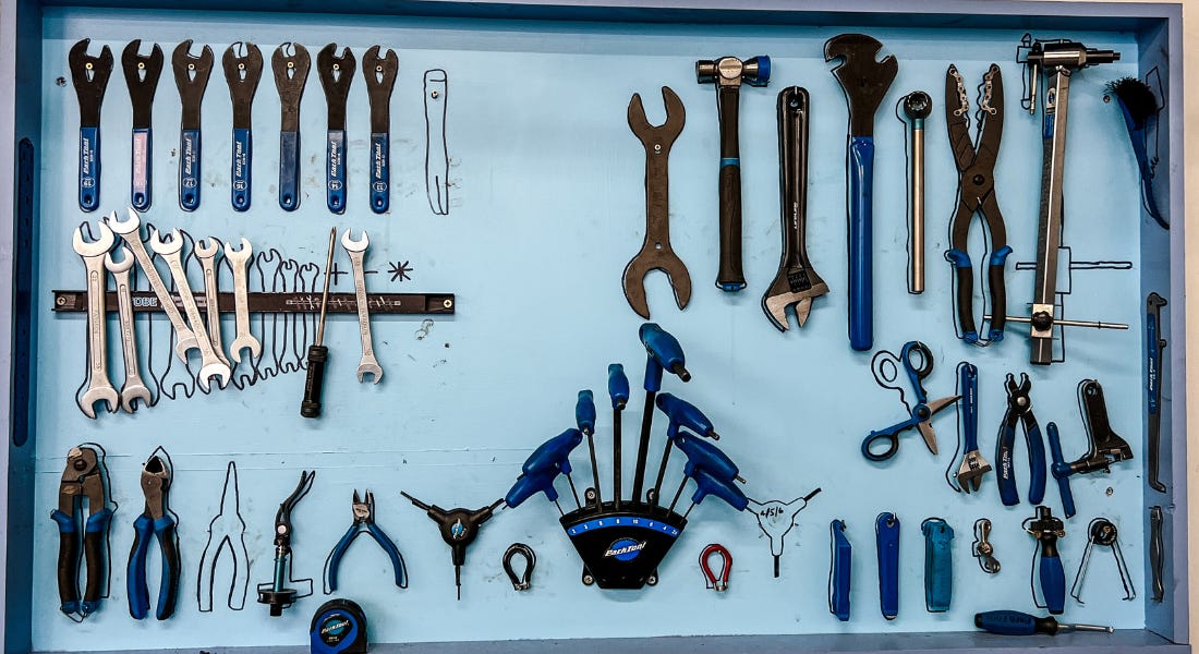 A birds eye view of a blue tool table with spanners, pliers, hammers, and more laid out A birds eye view of a blue tool table with spanners, pliers, hammers, and more laid out