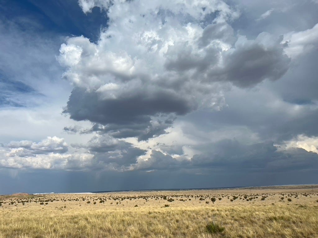 A cloudy sky over a field

Description automatically generated