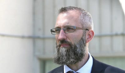 A person with a beard

Description automatically generated