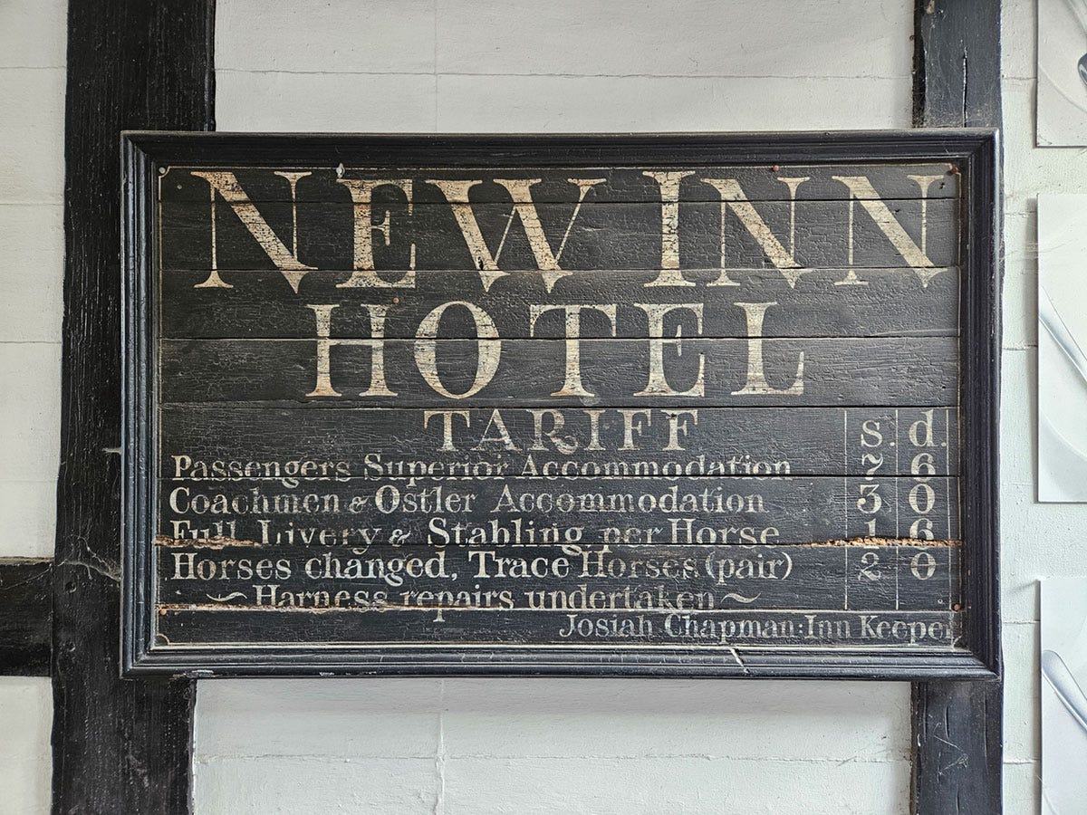 An old wooden sign showing the prices for staying in a Medieval coaching inn