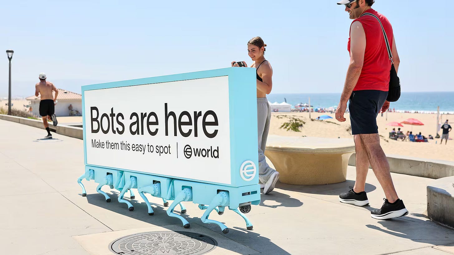 A beachside scene shows pedestrians stopping to look at a robot billboard that declares “Bots are here.”