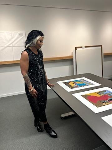 the artist in a black and white jumper looking at the Genesis Series in the Archives of the Henry Museum