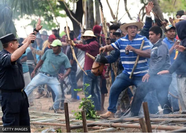 A group of people holding sticks and standing in a crowd

Description automatically generated