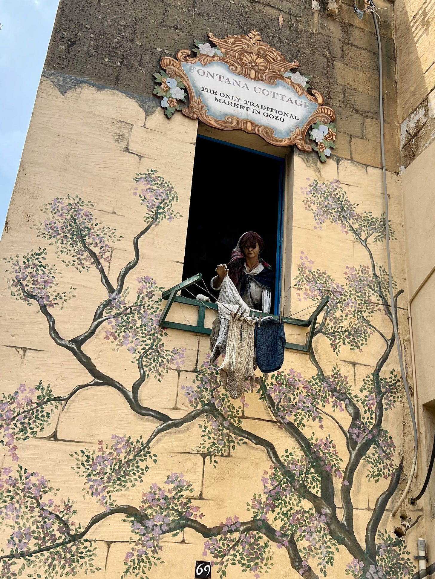 The whimsical laundry-hanging mannequin outside the Fontana Cottage Traditional Market, Gozo (Photo by © Marie Powell, used with permission under the Freedom of Panorama copyright law