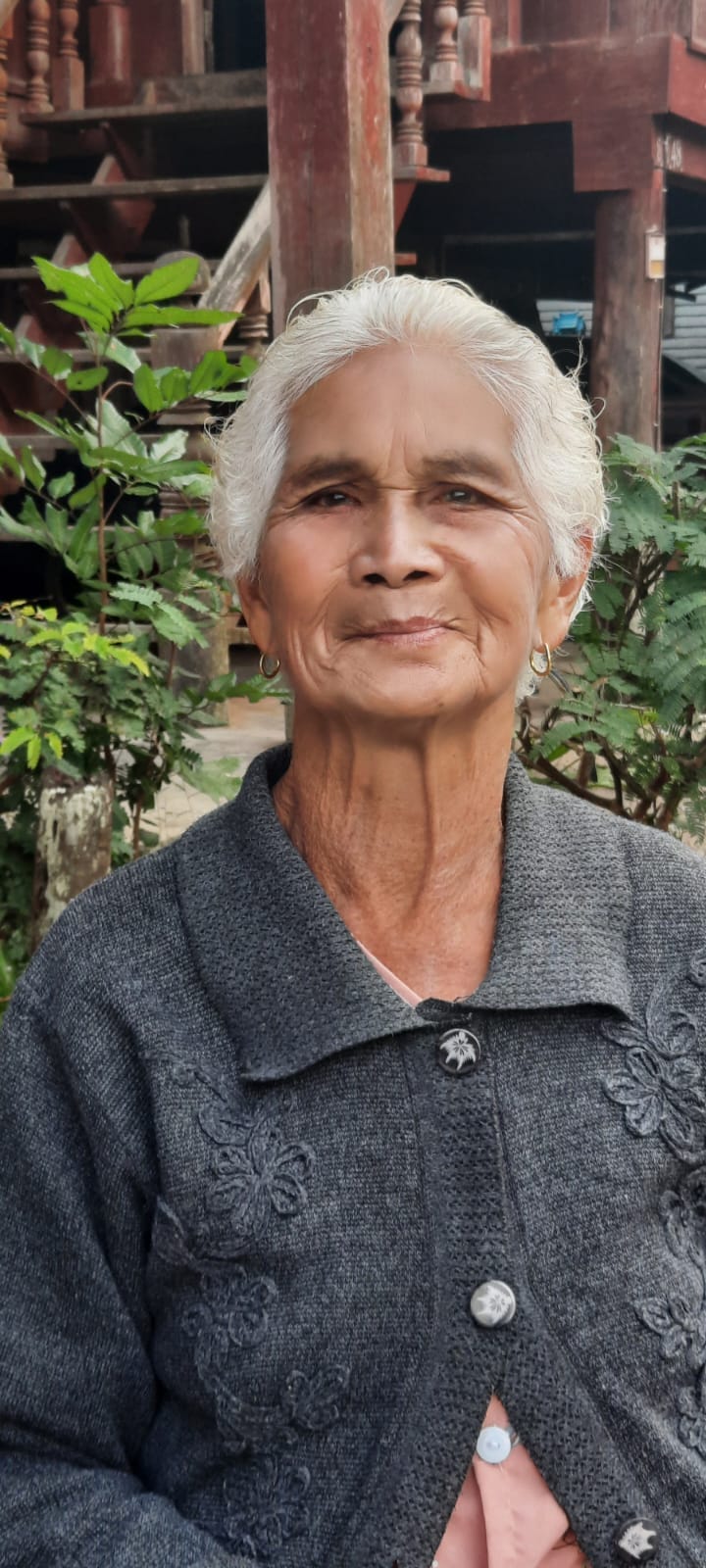 An old lady outside her house.