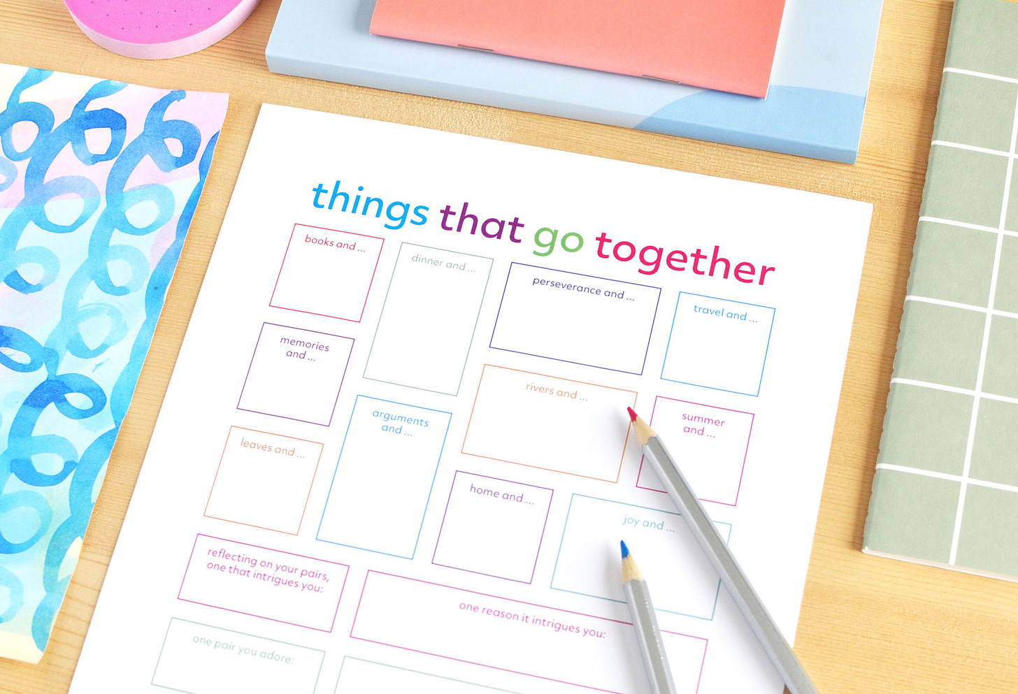 Things That Go Together printable journal page, filled with colourful prompts and writing spaces, pictured with colourful pencils and notebooks