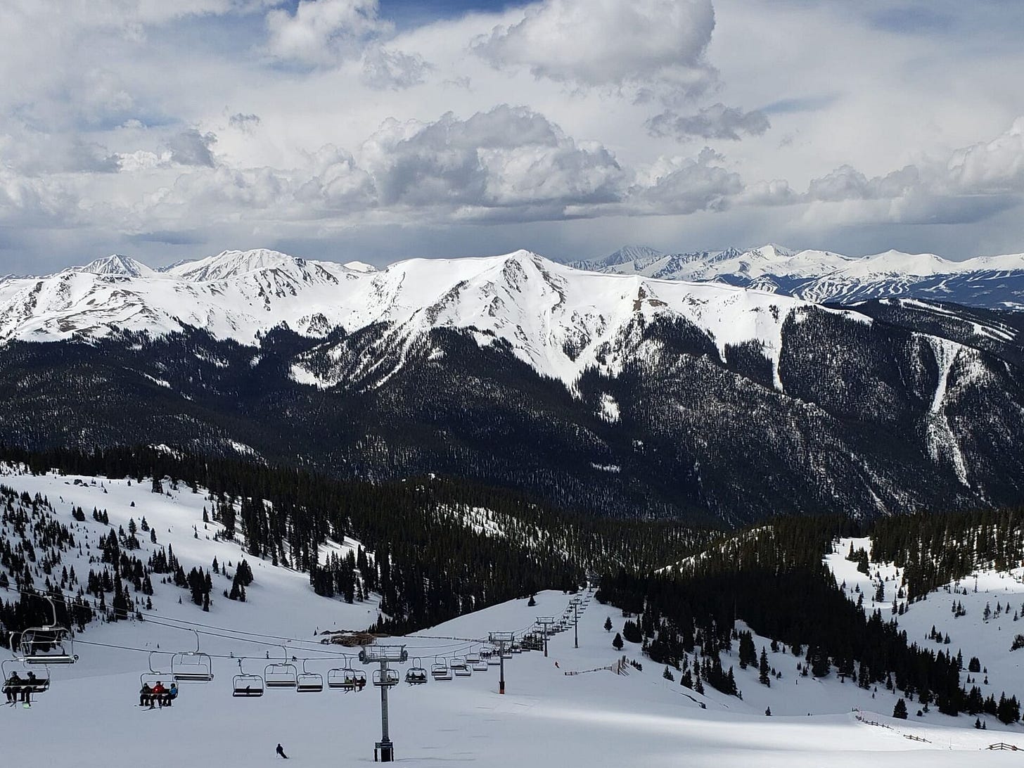 Chairlift above snowy slopes with high peaks across the valley near A-Basin Chairlift above snowy slopes with high peaks across the valley near A-Basin