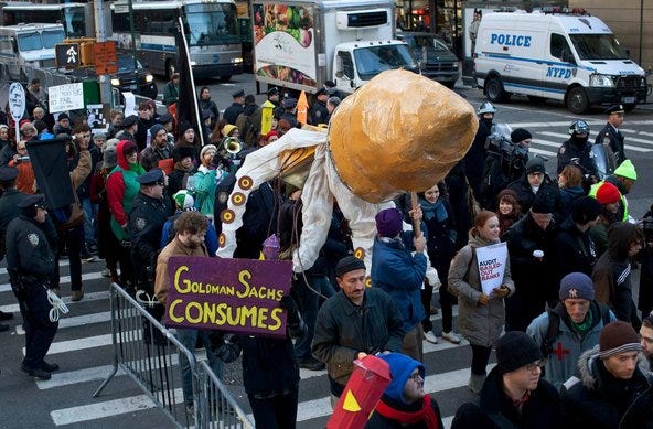 Protestors affiliated with the Occupy Wall Street movement carry a large squid puppet during a march to the offices of Goldman Sachs. Protestors affiliated with the Occupy Wall Street movement carry a large squid puppet during a march to the offices of Goldman Sachs.
