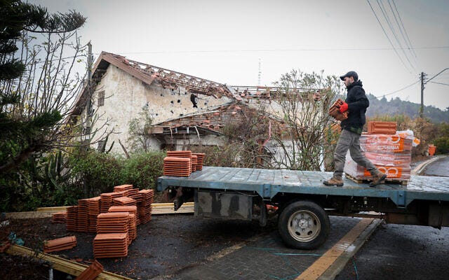 A man unloads construction materials in front of a damaged building in Metula, November 27, 2024. (David Cohen FLASH90) A man unloads construction materials in front of a damaged building in Metula, November 27, 2024. (David Cohen FLASH90)