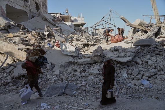 Palestinians walk among destroyed buildings in Gaza City, Thursday, Oct. 16, 2025. (AP Photo/Jehad Alshrafi)