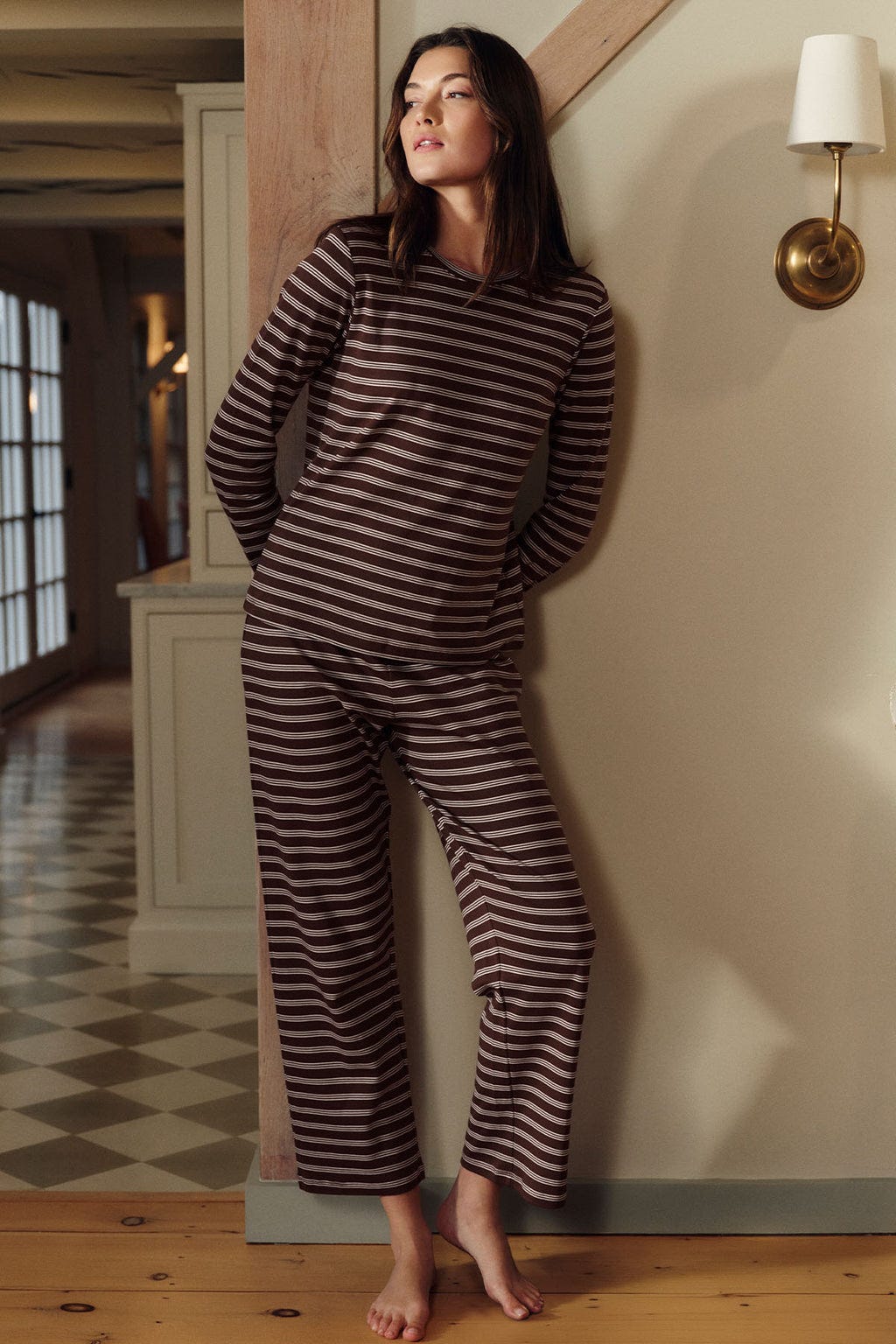 Woman wearing cocoa brown and cream striped long-sleeve crew neck top and matching cropped pants.