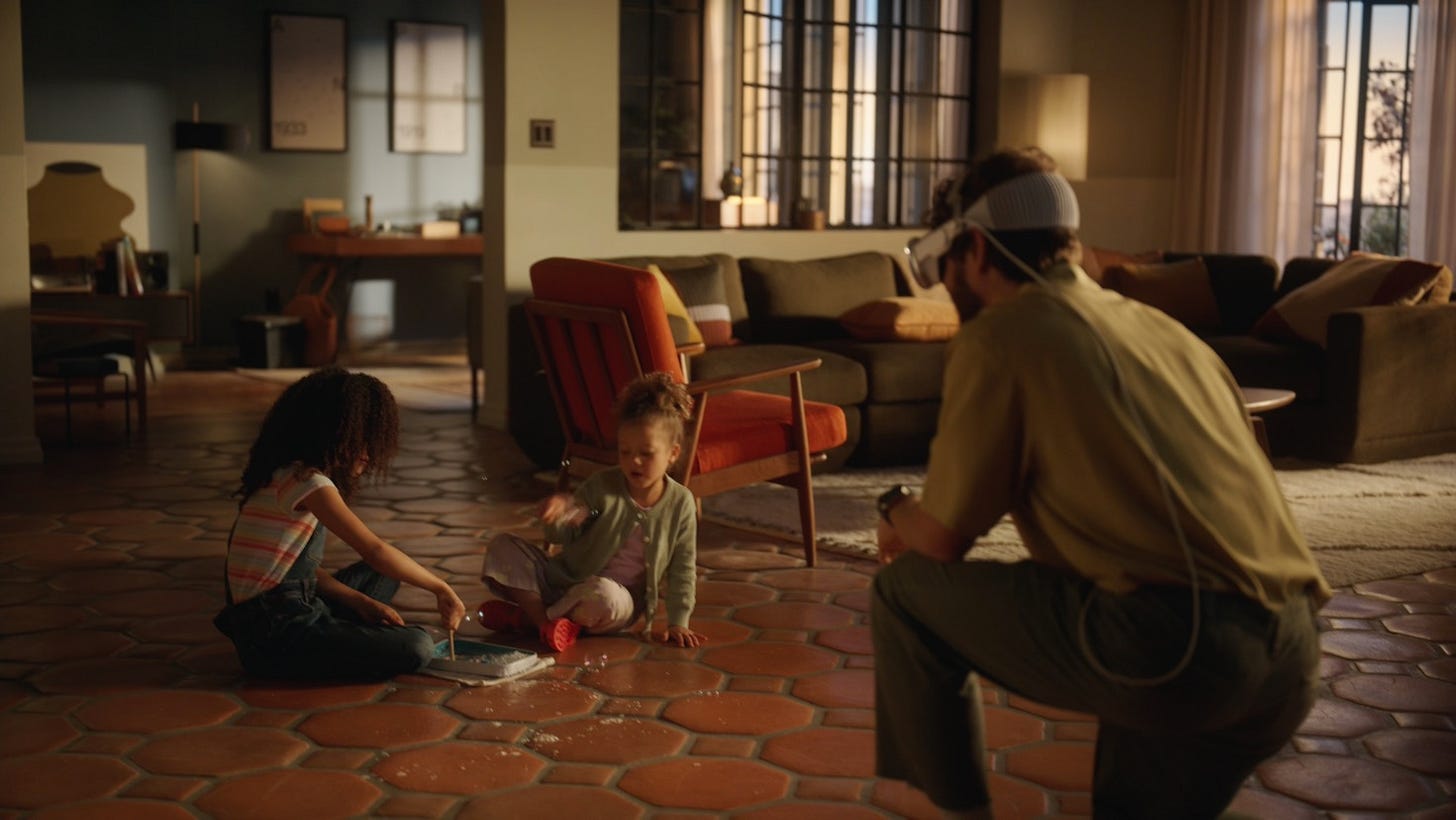 Two children playing in a living room, with a man wearing the VisionPro headset uses it to record video of them. Two children playing in a living room, with a man wearing the VisionPro headset uses it to record video of them.