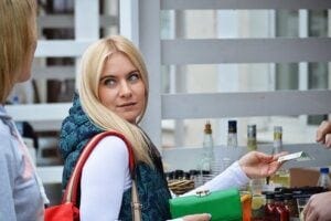 Blonde woman handing over credit card at store