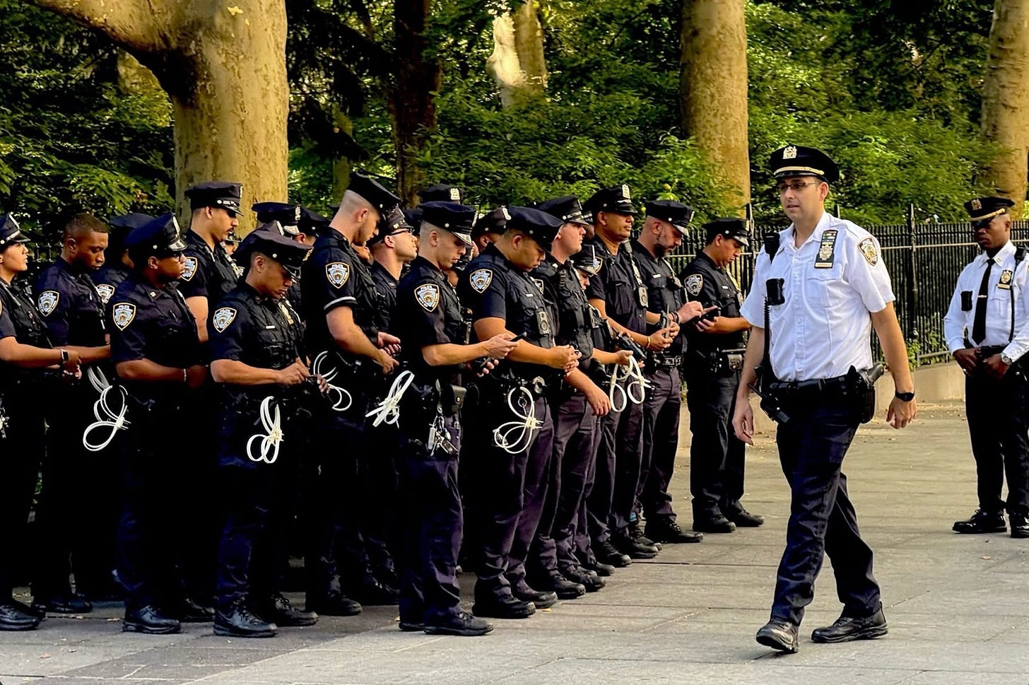 A group of police officers standing in a line

AI-generated content may be incorrect.