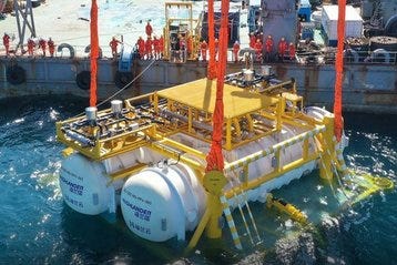 Subsea modular data center being lowered into the ocean using cranes, with crew members in orange uniforms overseeing deployment. Image represents underwater data center technology for sustainable cooling and energy-efficient data infrastructure.