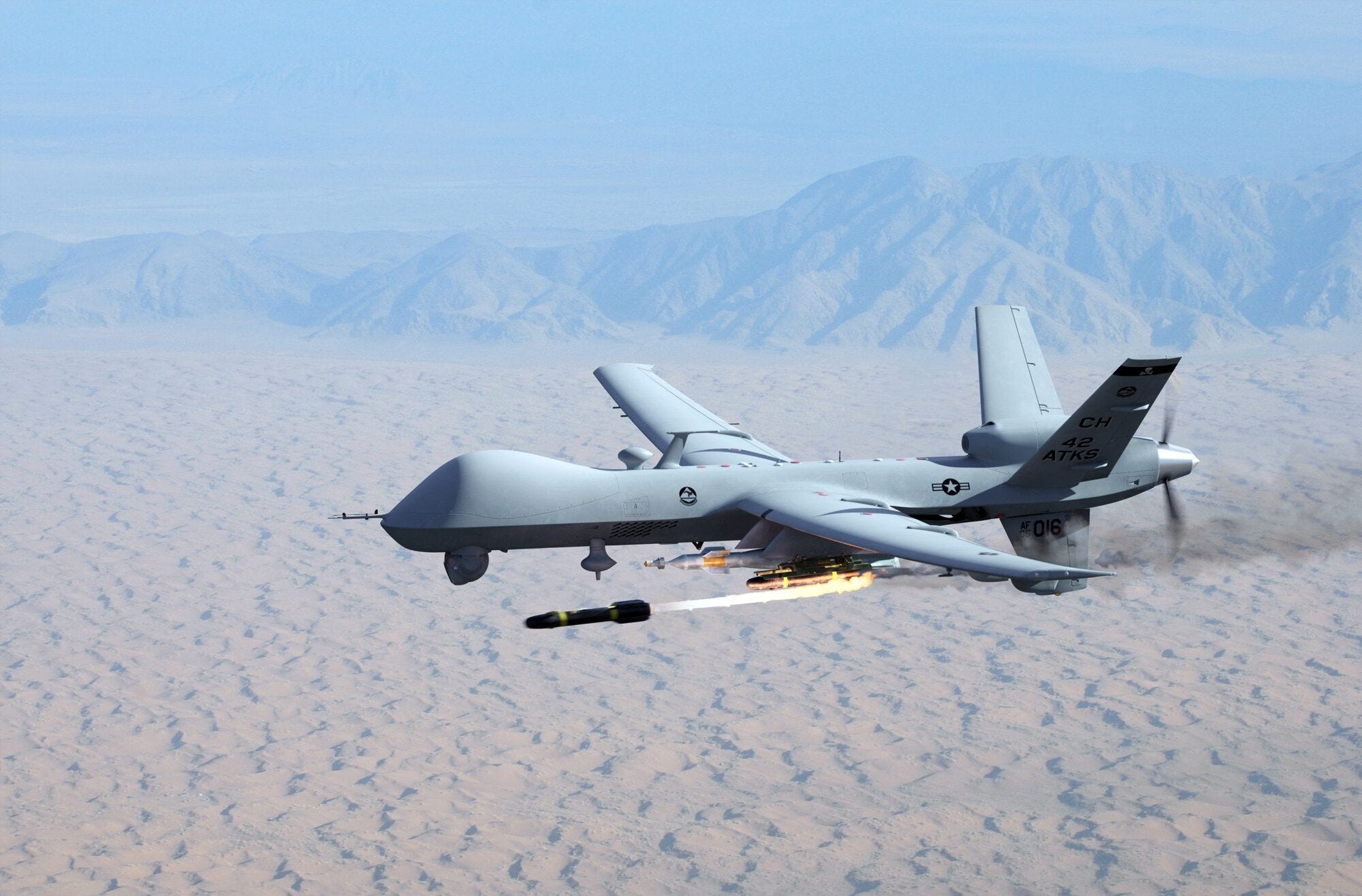 A U.S. Air Force MQ-9 Reaper fires an AGM-114 Hellfire missile over the Nevada desert.