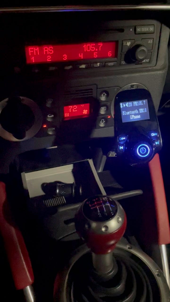 Photo of FM-to-Bluetooth Transmitter with FM Stereo in background