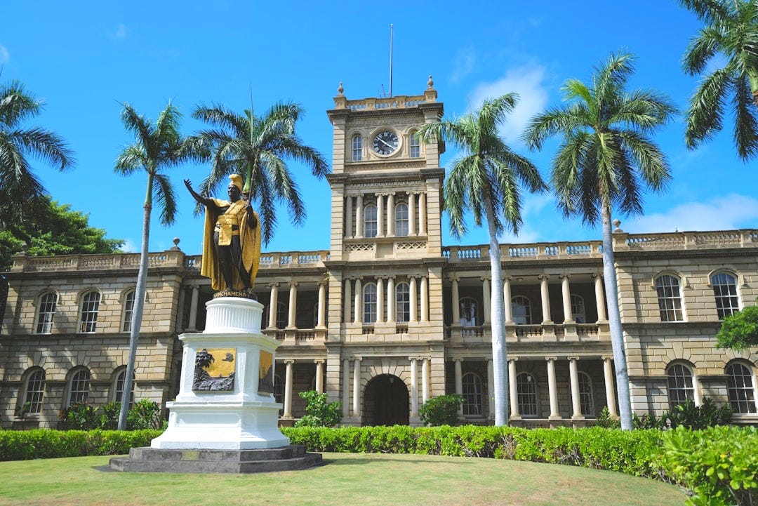 a statue in front of a large building with a clock tower