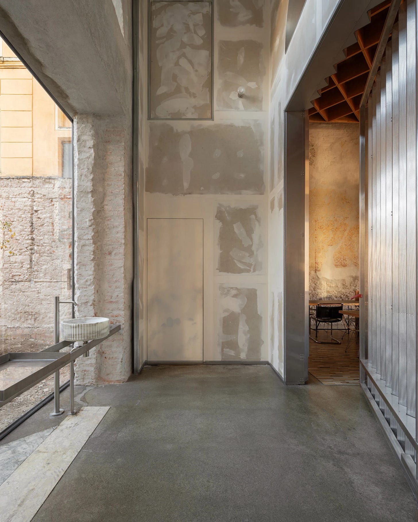 Caffè Nazionale by AMAA in Arzignano Italy, adaptive reuse of 19th-century palazzo with pleated stainless steel walls, okumè plywood ceiling and preserved historical patinas Caffè Nazionale by AMAA in Arzignano Italy, adaptive reuse of 19th-century palazzo with pleated stainless steel walls, okumè plywood ceiling and preserved historical patinas
